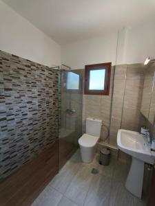 a bathroom with a toilet and a sink and a shower at Casa Stella in Mézapos +19 photos