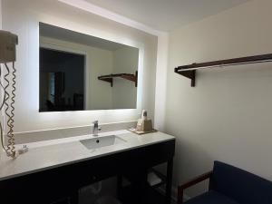 a bathroom with a sink and a large mirror at Travel Inn Buford near Mall of Georgia in Buford +16 photos