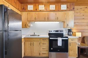 a kitchen with wooden cabinets and a stainless steel refrigerator at Chalet 71 in Stevensville +38 photos
