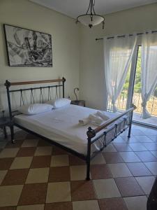 a bed in a bedroom with a large window at La Casa Tzortzina in Kokkino Nero