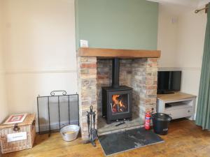 a brick fireplace in a room with a tv at Bay Cosy in Pevensey
