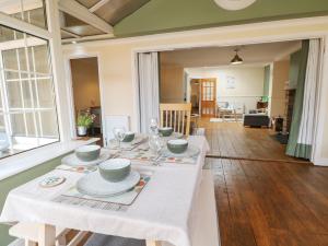 a dining room with a table with a white table cloth at Bay Cosy in Pevensey