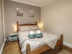 a bedroom with a bed with two teddy bears on it at Bay Cosy in Pevensey