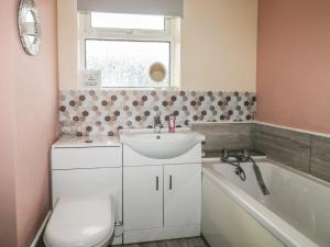 a bathroom with a sink and a toilet and a tub at Bay Cosy in Pevensey +19 photos
