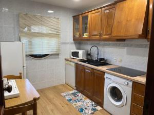 a kitchen with a washing machine and a microwave at My Little Beach House in Praia da Barra