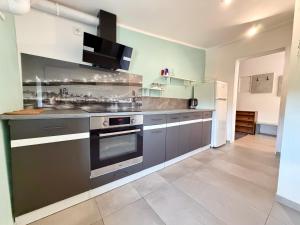 a kitchen with stainless steel appliances in a room at Park Leśnicki Homely Studios by BookingHost in Wrocław