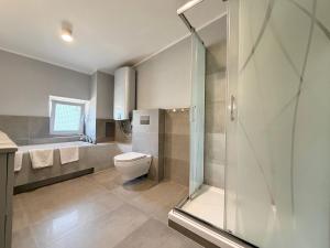 a bathroom with a toilet and a shower and a sink at Park Leśnicki Homely Studios by BookingHost in Wrocław +34 photos