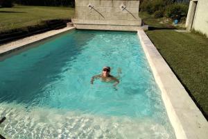a man in a swimming pool in a yard at Mas des Treilles - Chambre d'hôtes - Côté Campagne in Mane +2 photos