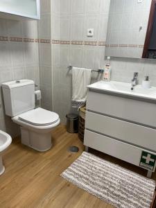 a bathroom with a toilet and a sink at My Little Beach House in Praia da Barra