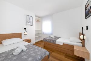 two beds in a room with white walls and wooden floors at Villa Rocco in Srima +92 photos