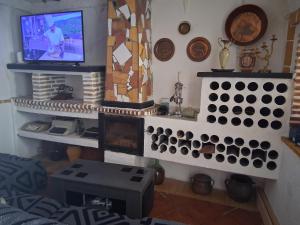 a living room with a fireplace and a tv at Casa rural las conchas in Cazalla de la Sierra