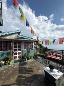 a house with prayer flags in front of it at White Sea Homestay, Dowhill Kurseong in Kurseong