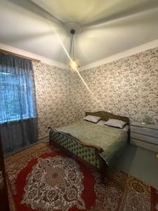 a bedroom with a bed in a room with wallpaper at Aygut Garden in Aygut