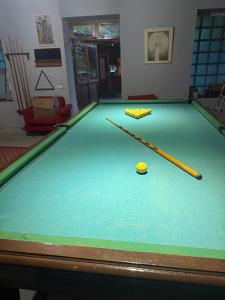 a pool table with two cue sticks and a ball at Aygut Garden in Aygut