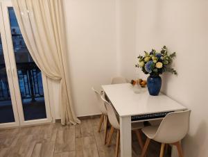 a white dining room table with a vase of flowers on it at Moussa Erato in Agia Anna Naxos +5 photos