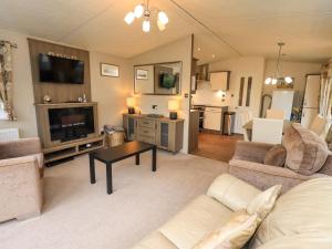a living room with a couch and a tv at 41, Grandma's Cottage in Carnforth