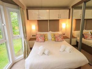 a bedroom with a large white bed with pillows at 41, Grandma's Cottage in Carnforth