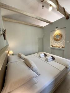 two beds in a room with a mirror on the wall at Villa Kaldera Skiathos in Skiathos