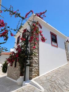 a white building with red flowers on it at Villa Kaldera Skiathos in Skiathos