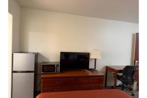 a room with a desk with a microwave and a refrigerator at Travel Inn Buford near Mall of Georgia in Buford