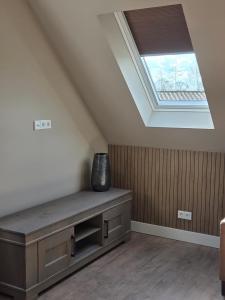 a skylight in a loft with a vase on a bench at Erve Ther Maet in Weerselo