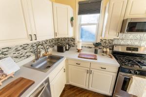 a kitchen with white cabinets and a sink at Bucktown Private Condo in Chicago