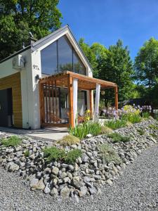 a house with a porch and a rock garden at Nad Strumieniem in Pieszyce