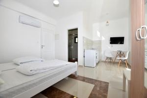 a white room with a bed and a kitchen at Jednosoban stan Milinic in Herceg-Novi