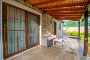 a screened in porch with a couch and a chair at Villa Masal in Kayakoy