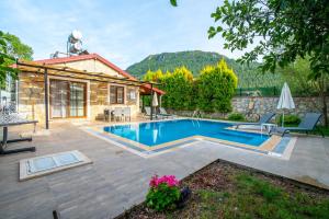 a house with a swimming pool in a yard at Villa Masal in Kayakoy