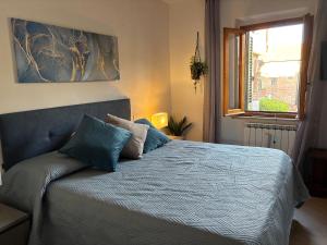 a bedroom with a bed with blue sheets and a window at Vicolo dell'Orto in Montaione