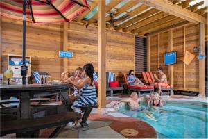 a group of people sitting around a swimming pool at Great Wolf Lodge Waterpark Resort in Niagara Falls