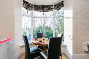 a dining room with a table and chairs and a window at Station View Guest House in Dyce