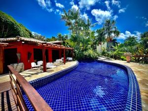 a swimming pool in front of a house at Villas do Pratagy VIP in Maceió