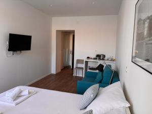 a living room with a bed and a blue chair at Ridzak Riva Rooms in Mali Lošinj