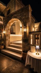 a stone archway with stairs and a table with a lamp at Knossos Breeze in Sitia