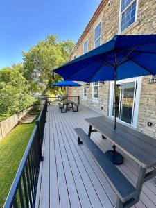 a wooden deck with two benches and an umbrella at River Stone Villa - 2Bedroom/2Bath - No Step Entry in Bellevue