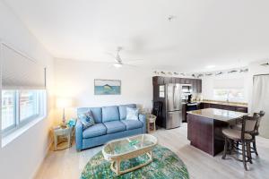 a living room with a blue couch and a kitchen at Snowbird-friendly condo in oceanfront complex with heated pool, BBQ, AC in Marathon
