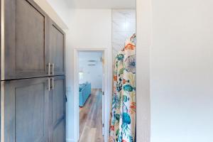 a hallway with a door leading into a room with a curtain at Snowbird-friendly condo in oceanfront complex with heated pool, BBQ, AC in Marathon +20 photos