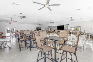 a dining room with tables and chairs and a ceiling fan at Snowbird-friendly condo in oceanfront complex with heated pool, BBQ, AC in Marathon