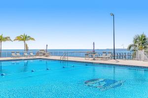 a swimming pool with the ocean in the background at Snowbird-friendly condo in oceanfront complex with heated pool, BBQ, AC in Marathon