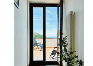 a sliding glass door leading to a balcony with a chair at Near Acquamorta Beach - Villa Lamberti Casa Sole in Monte di Procida