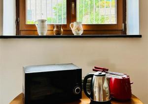 a microwave and a tea kettle on a table at Near Acquamorta Beach - Villa Lamberti Casa Sole in Monte di Procida
