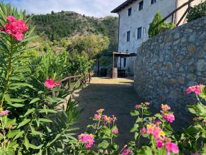 ein Garten mit rosa Blüten und einer Steinmauer in der Unterkunft Il Muraglio in Belmonte Calabro