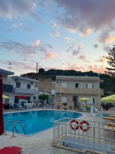 a view of a swimming pool with a building at Avlή Apartments I in Kamári