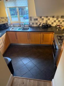a kitchen with a sink and a stove at Lake Lounge Rooms in Littleborough