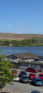 a parking lot with cars parked in front of a building at Lake Lounge Rooms in Littleborough