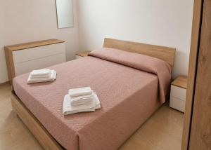 a bedroom with a bed with two towels on it at Dimora Azzurra in Pachino