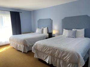 two beds in a room with blue walls at The Lakes at Ben Eoin Golf Club & Resort in Big Pond