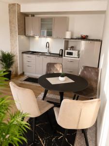 a kitchen with a table and chairs in a room at Apartment Arma in Mostar